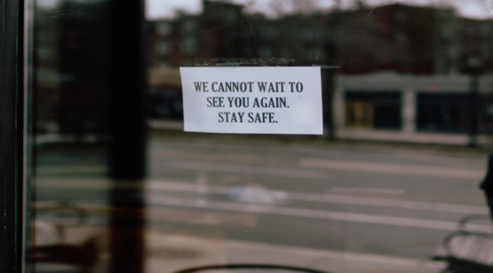 "A sign on a door saying We cannot wait to see you again, stay safe"