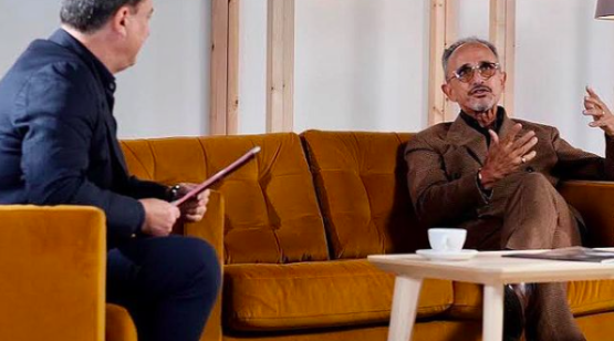 Jeffrey Young interviewing Kamal Bengougam for The Global Coffee Festival. Sitting on a yellow couch with coffee in the foreground.