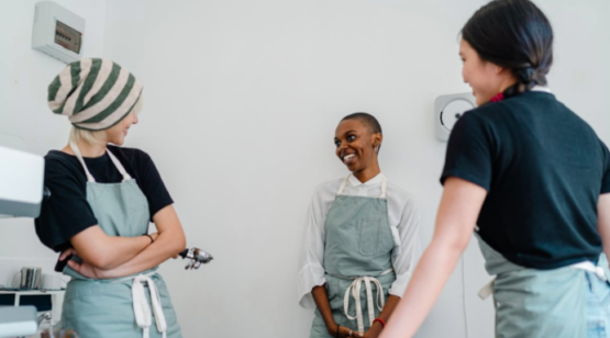 Three coffee shop employees talking.